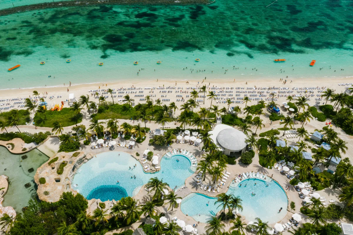 Beachfront resort pools beside turquoise coastal water