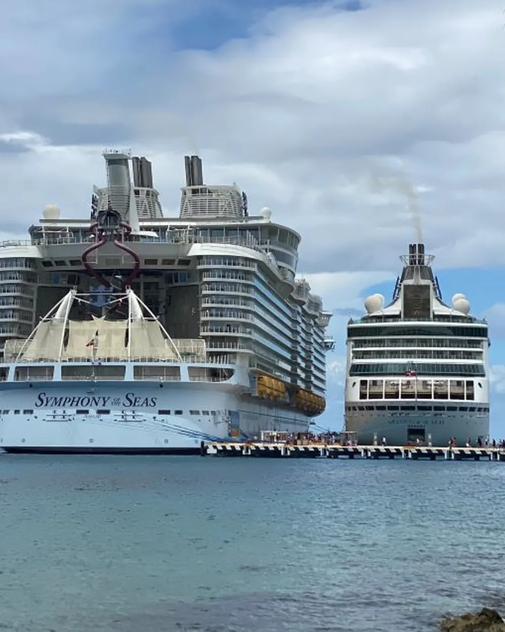 Symphony of the Seas beside a smaller cruise ship